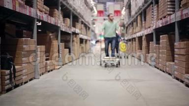 一个人推着一辆手推车，在仓库里放着一个盒子，正走进摄像机，慢慢地集中注意力